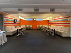 a dining room with tables and chairs and orange walls at PracticOtel Kyiv in Kyiv