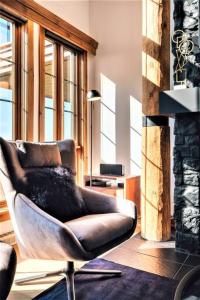 a living room with a chair in front of a fireplace at Tremblant Prestige - Équinoxe 164-2 in Mont-Tremblant