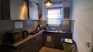 a small kitchen with a sink and a microwave at Ferienwohnung Berlin - Schönefeld Flughafen mit Küche in Schönefeld