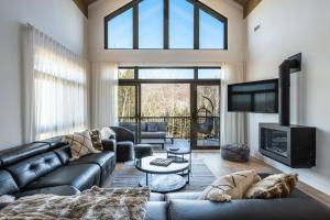 a living room with a leather couch and a tv at Tremblant Prestige - Verbier 3-201 in Mont-Tremblant