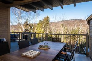 a table on a balcony with a view of the mountains at Tremblant Prestige - Verbier 3-201 in Mont-Tremblant +42 photos