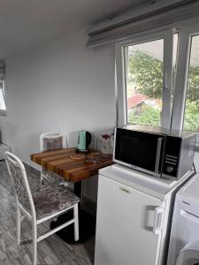 a kitchen with a microwave on top of a refrigerator at REBL Suites in Sutješčica