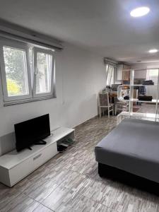 a bedroom with a bed and a flat screen tv at REBL Suites in Sutješčica