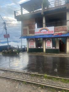 a building on a street in the rain at The Rainbow Inn in Sonāda