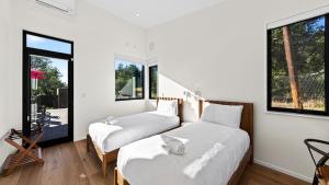two beds in a room with white walls and windows at Olive Oak by AvantStay in Glen Ellen +51 photos