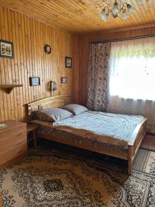 a bedroom with a bed and a window at Буркут in Yaremche
