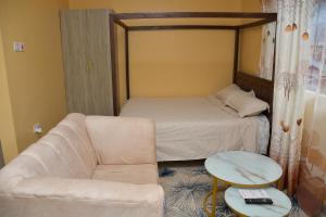 a living room with a couch and a bed at Maria Villa Studio in Voi
