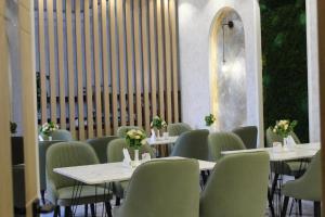 a dining room with tables and chairs with flowers on them at Art Moderno Hotel in Tashkent