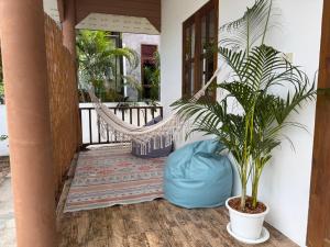 a porch with a hammock and a potted plant at Thong Sala Japandi Villa in Thong Sala