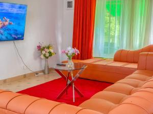 a living room with orange couches and a table at Oceana Villa in Mombasa