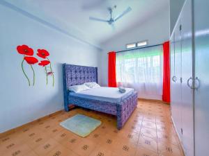 a bedroom with a bed and a window with red curtains at Oceana Villa in Mombasa +5 photos
