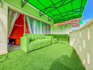 a living room with green furniture and green carpet at Oceana Villa in Mombasa