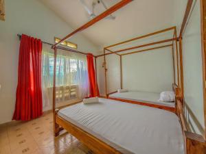 a bedroom with two beds and a window with red curtains at Oceana Villa in Mombasa
