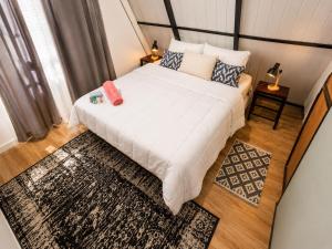 a bedroom with a large white bed and a rug at Cabaña Alpina - Ecos del Cerro in Paraguarí +21 photos