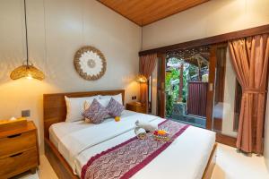 a bedroom with a bed with a stuffed animal on it at Ubud Heritage Stay by Dhananjaya Hospitality in Ubud