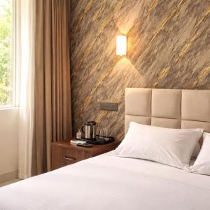 a hotel room with a bed and a nightstand at Hotel nine hearts in Pānīpat +2 photos