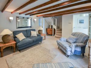 a living room with a couch and a chair at Fuchsia Cottage in Saint Mawes