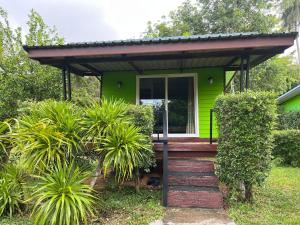 a green house with a staircase leading to the front door at Kohpu garden in Ban Klang