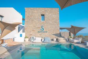 a swimming pool with chairs and a building at Sofrano Luxury Apartments in Evdilos +14 photos