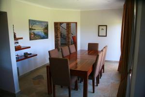 a dining room with a wooden table and chairs at Avocado Grove Guest House in White River
