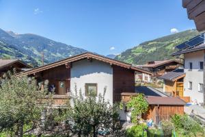 a house in a village with mountains in the background at Ferienwohnung Sylvia in Ramsau im Zillertal