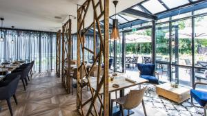 a restaurant with tables and chairs and large windows at Mezger Lodges in Domburg