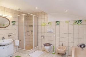 a bathroom with a sink and a toilet and a urinal at Ferienwohnung Sylvia in Ramsau im Zillertal