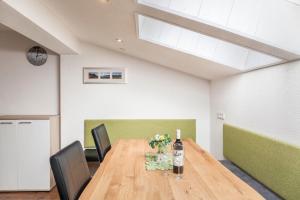 a dining room with a table with flowers and a bottle of wine at Ferienwohnung Sylvia in Ramsau im Zillertal +15 photos