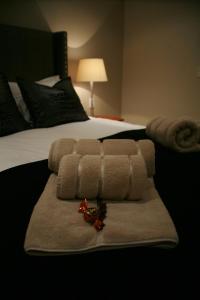 a hotel room with a bed with a pile of towels at Avocado Grove Guest House in White River +36 photos