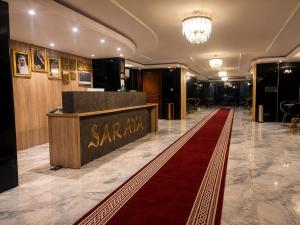 a hotel lobby with a red carpet and a reception desk at سرايا الغربية للشقق المخدومة - saraya algharbiyya Establishment in Jeddah