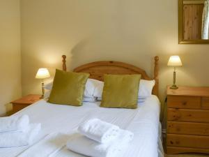 a bedroom with a white bed with two lamps at Fordson in Warenford