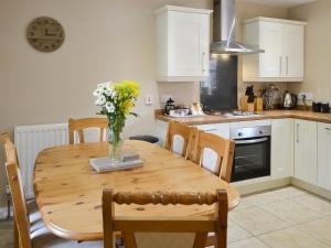 a kitchen with a wooden table with a vase of flowers on it at Fordson in Warenford