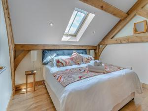a bedroom with a large bed in a attic at Y Llaethdy - Uk49916 in Penclawdd