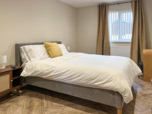 a bedroom with a bed with white sheets and a window at Barncroft Retreat - Uk51693 in Flimby