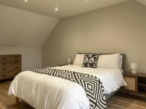 a bedroom with a bed with a black and white comforter at Barncroft Retreat - Uk51693 in Flimby +10 photos