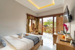 a bedroom with a bed and a balcony at Ubud Heritage Stay by Dhananjaya Hospitality in Ubud