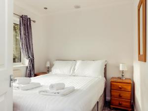 a bedroom with a bed with two towels on it at Chalet 4 in Flookburgh +12 photos