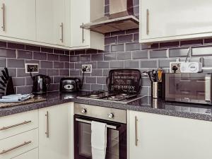 a kitchen with white cabinets and a stove top oven at Chalet 4 in Flookburgh