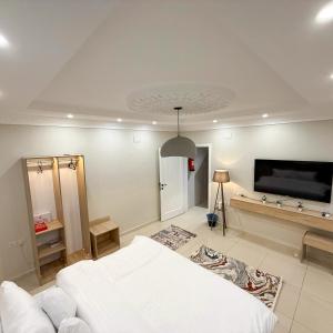 a bedroom with a white bed and a flat screen tv at Nasaem Al Naseem in Medina