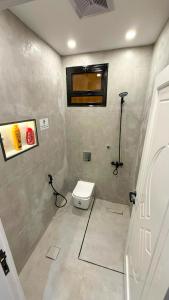 a small bathroom with a toilet and a window at Nasaem Al Naseem in Medina
