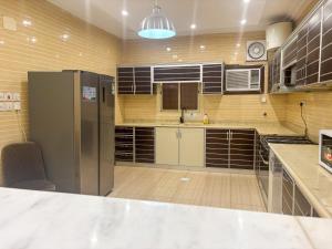 a large kitchen with a refrigerator in a room at Nasaem Al Naseem in Medina