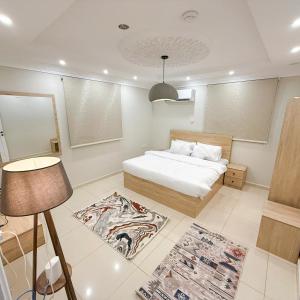 a bedroom with a bed and a lamp and a rug at Nasaem Al Naseem in Medina