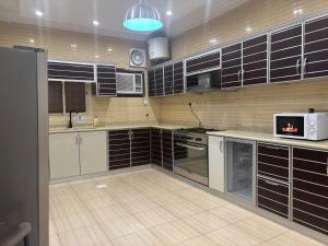 a kitchen with black and white cabinets and a microwave at Nasaem Al Naseem in Medina +7 photos
