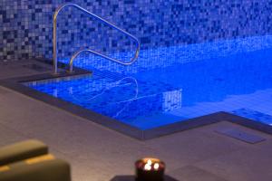 a swimming pool with a hand rail and a candle at Mezger Lodges in Domburg