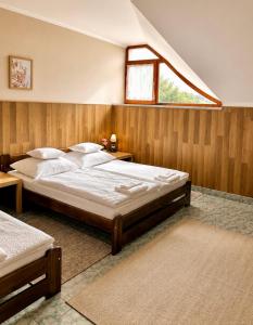 a bedroom with a large bed and a window at Muskátli Panzió és Étterem in Újhartyán