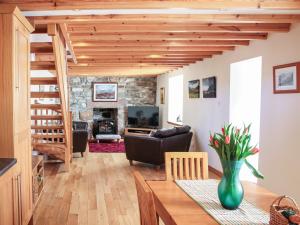 a living room with a staircase and a living room with a table at Hill Cottage in Ardmair