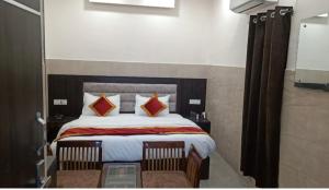 a bedroom with a large bed with two chairs at Hotel Park Blu in Pānīpat