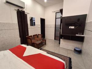 a hotel room with a bed and a tv at Hotel Park Blu in Pānīpat