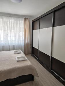 a bedroom with a bed and a large window at Apartman Matej in Gospić