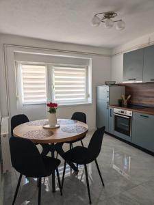 a kitchen with a table and chairs in a kitchen at Apartman Matej in Gospić